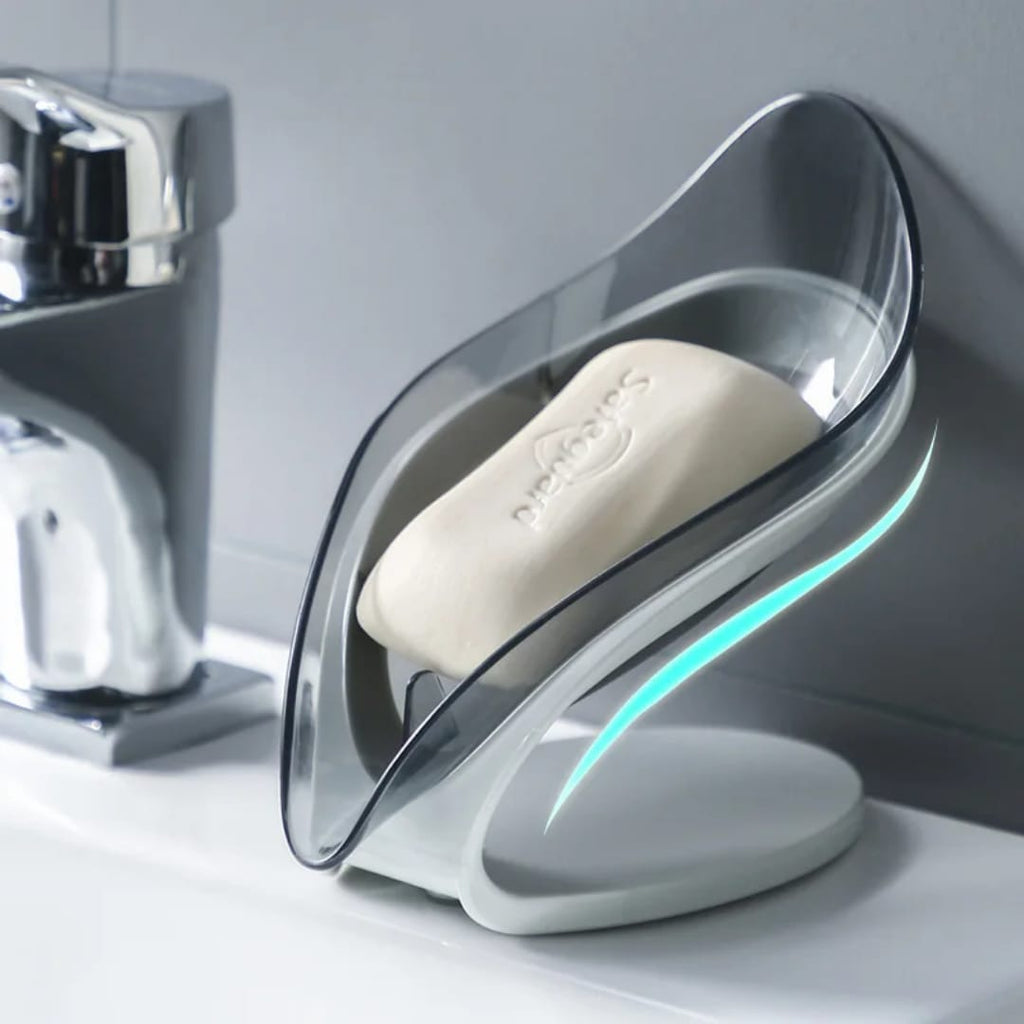 Leaf-shaped soap dish holding a bar of soap next to bathroom sink